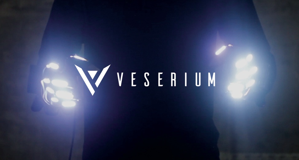 man on black holding lighting text veserium