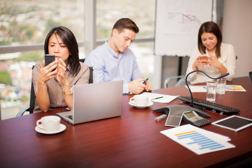 employees staring on their mobile phones at the office