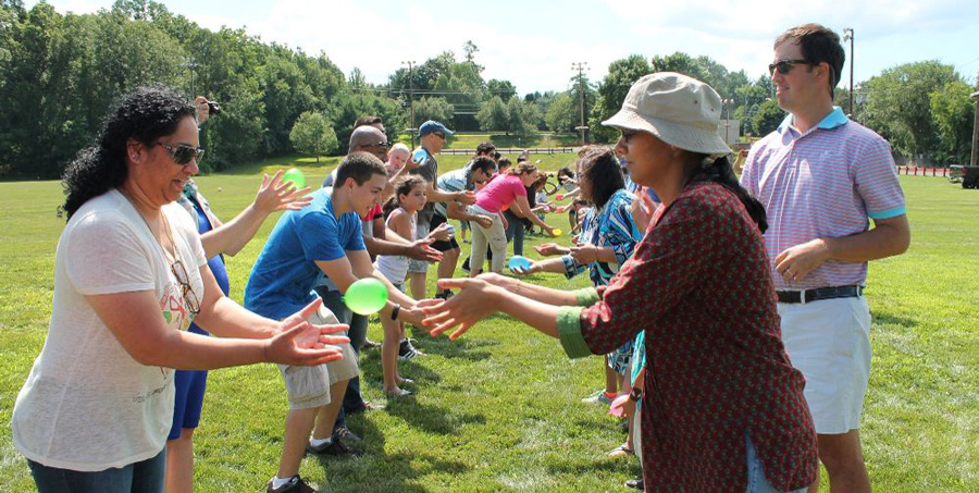 families playing water balloon toss game