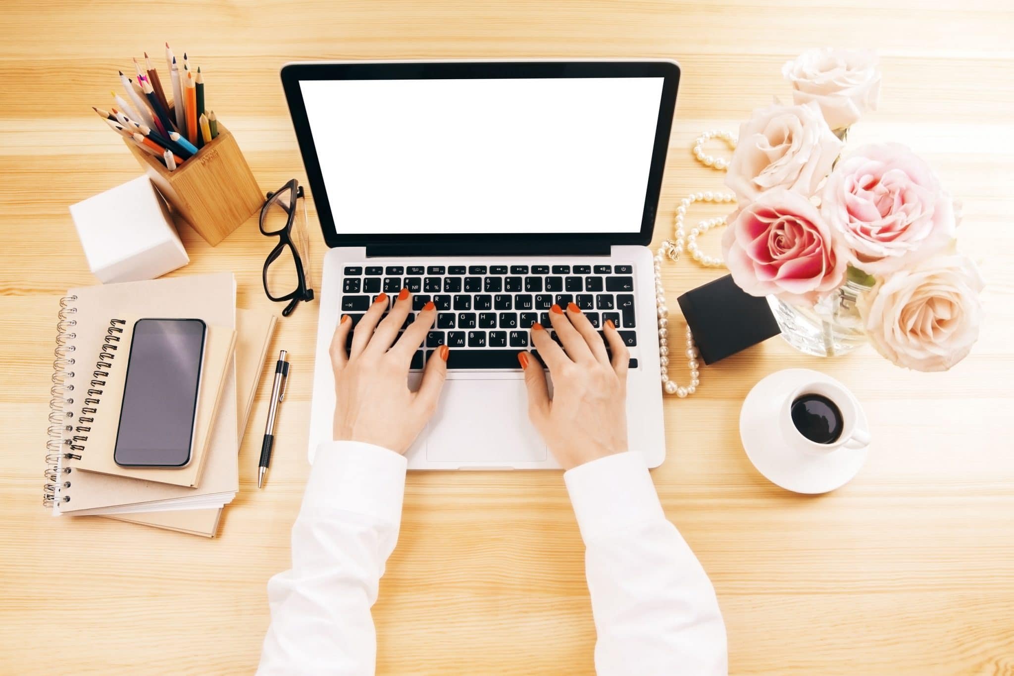 Woman hand typing keyboard on desk table with office supplies, blank screen laptop