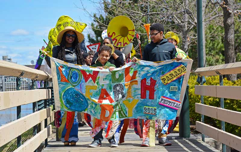 people holding banner for earth day event