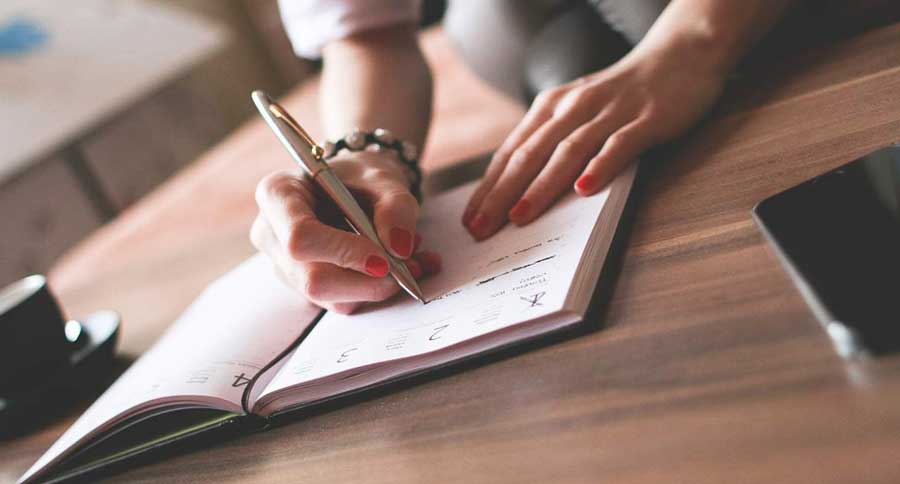 a woman writing on a notepad