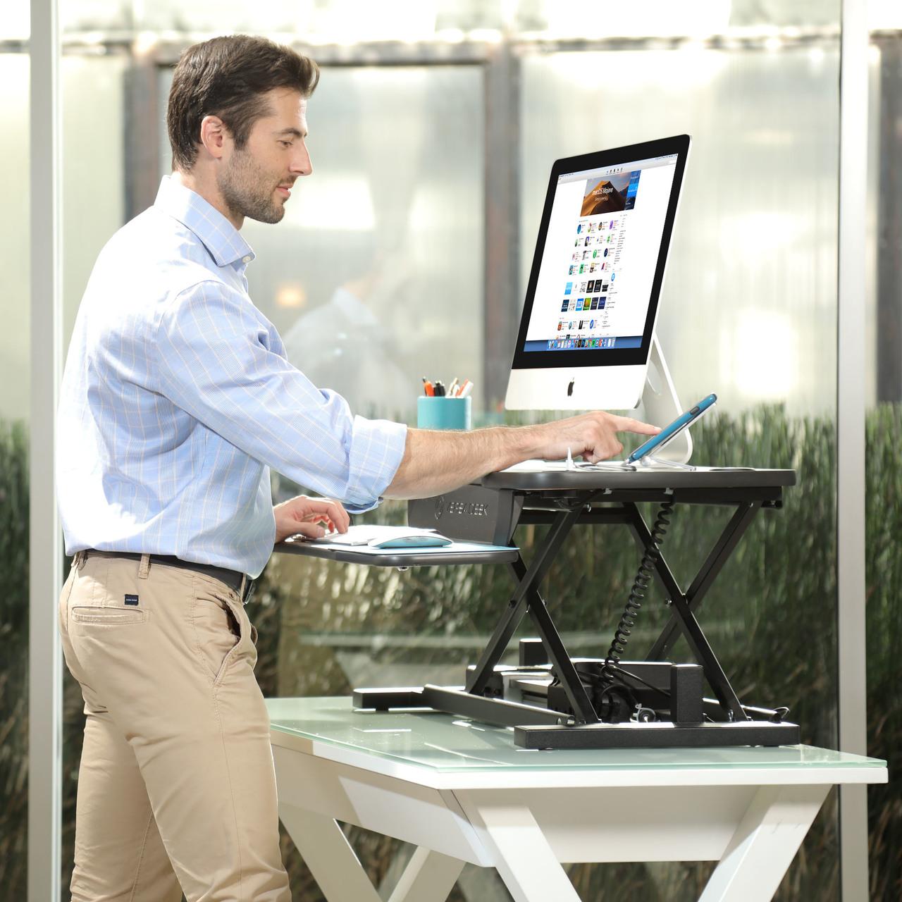 a man using stand up desk for his laptop