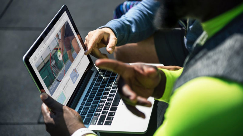 two men are watching videos on their laptop