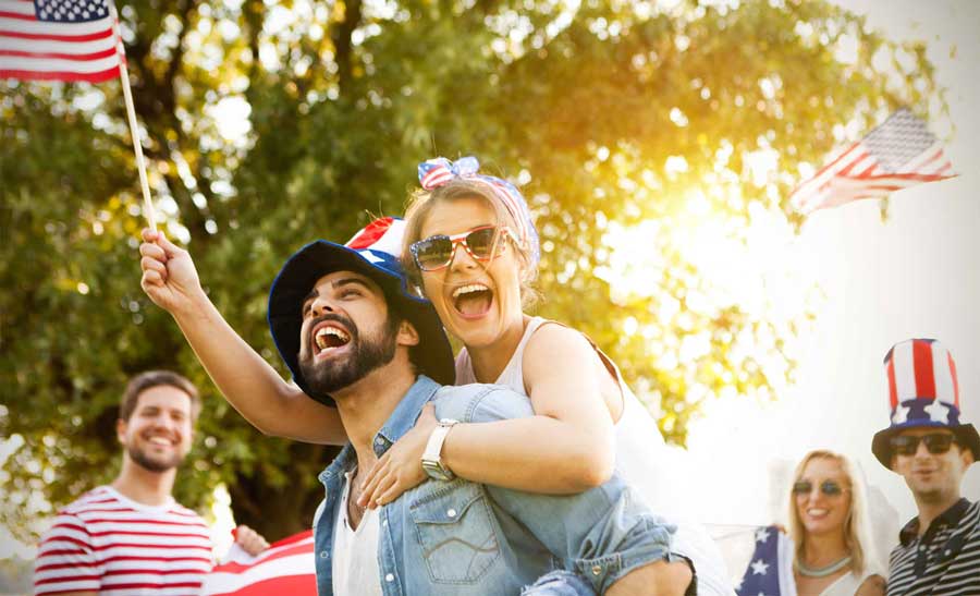 a happy couple attending Independence day events with other people smiling on their back 