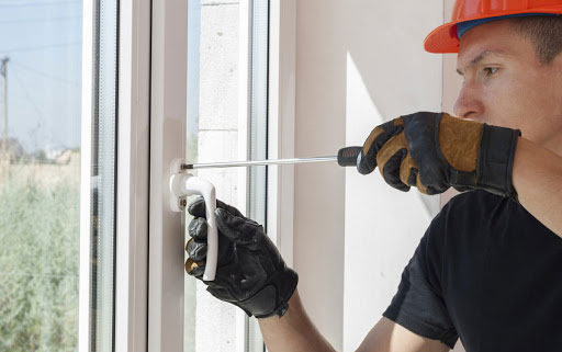 a man installing a glass window in a house