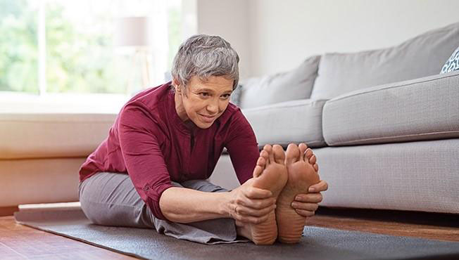 an older woman stretching her legs