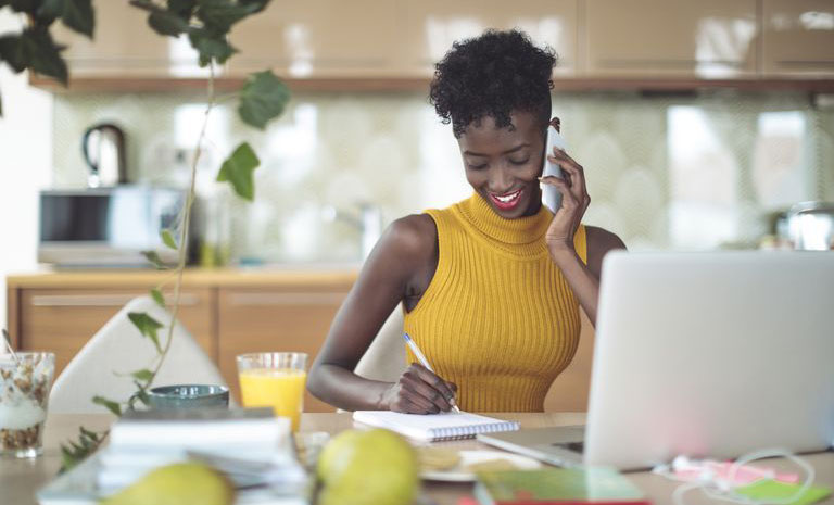 a-woman-wearing-a-bright-yellow-shirt-holding-the-phone