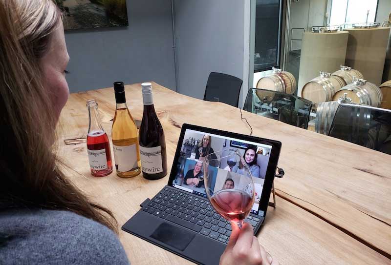 a-women-on-her-laptop-at-a-winery-tasting-wine