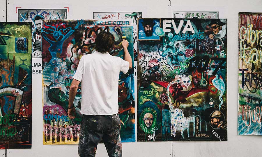 A Man Painting A Picture On A Wall 