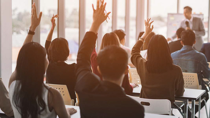 People-raising-their-hand-at-a-seminar